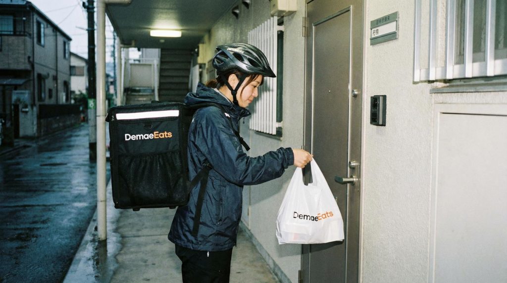 置き配をする女性フードデリバリー配達員
